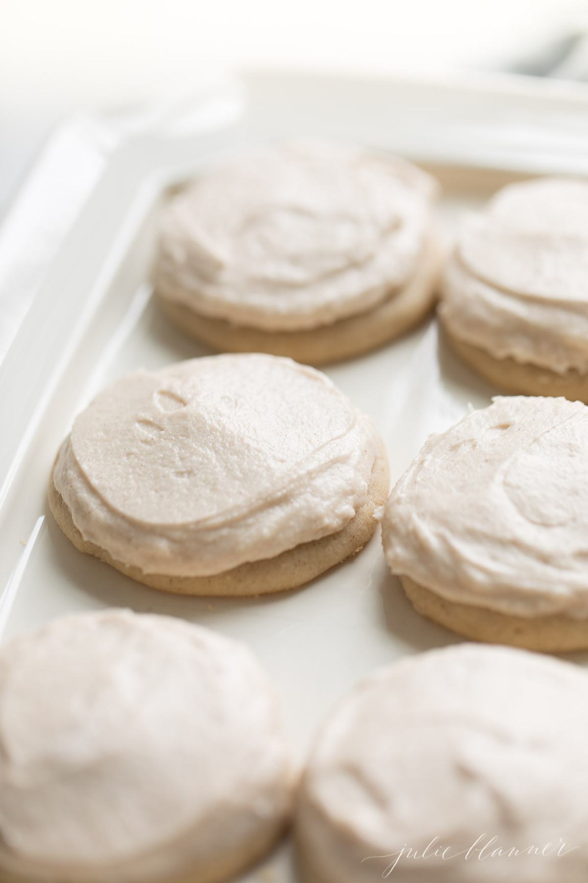 Iced cinnamon sugar cookies on a white platter