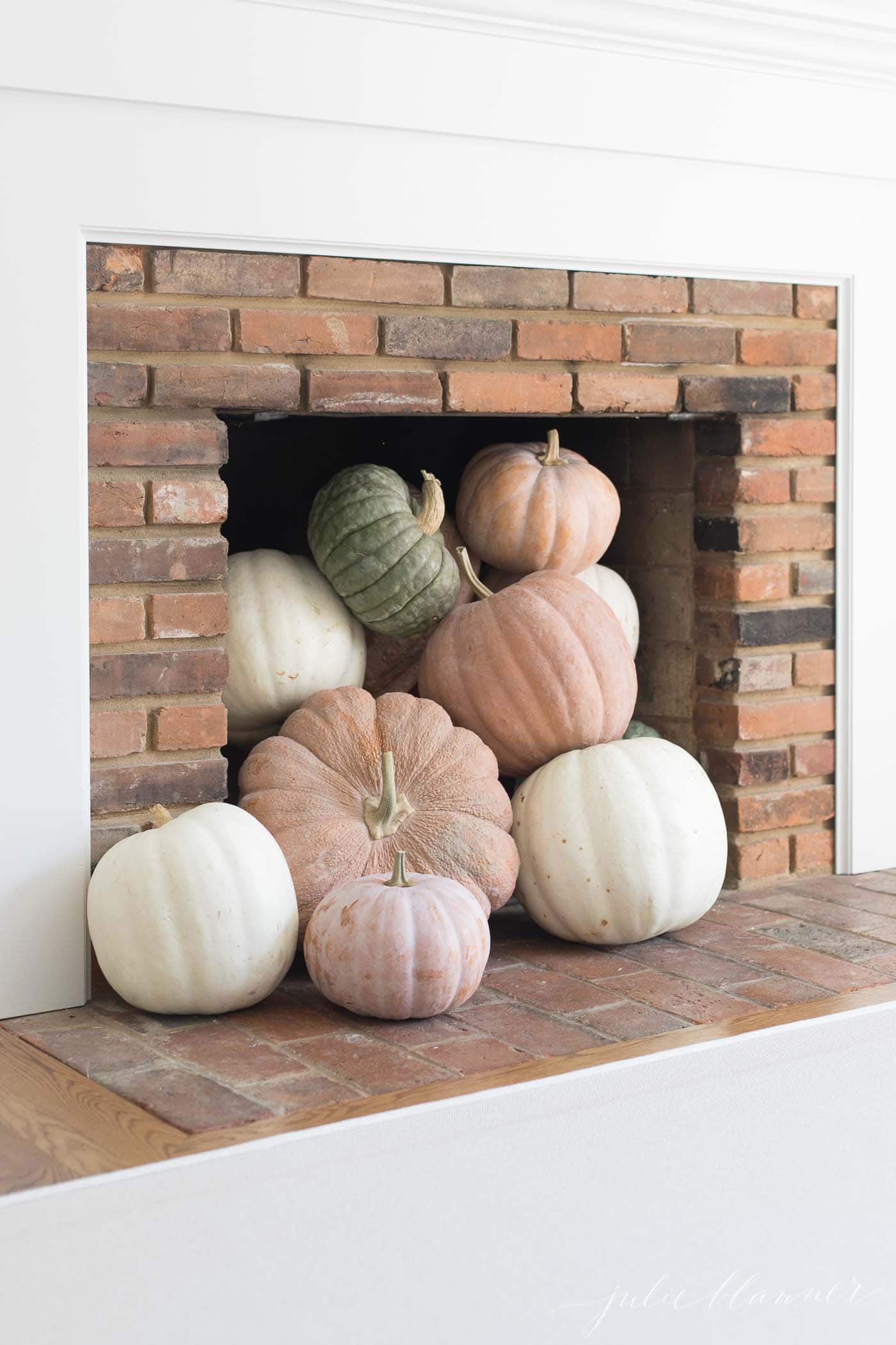 heirloom pumpkins in a fireplace for a fall living room decor idea