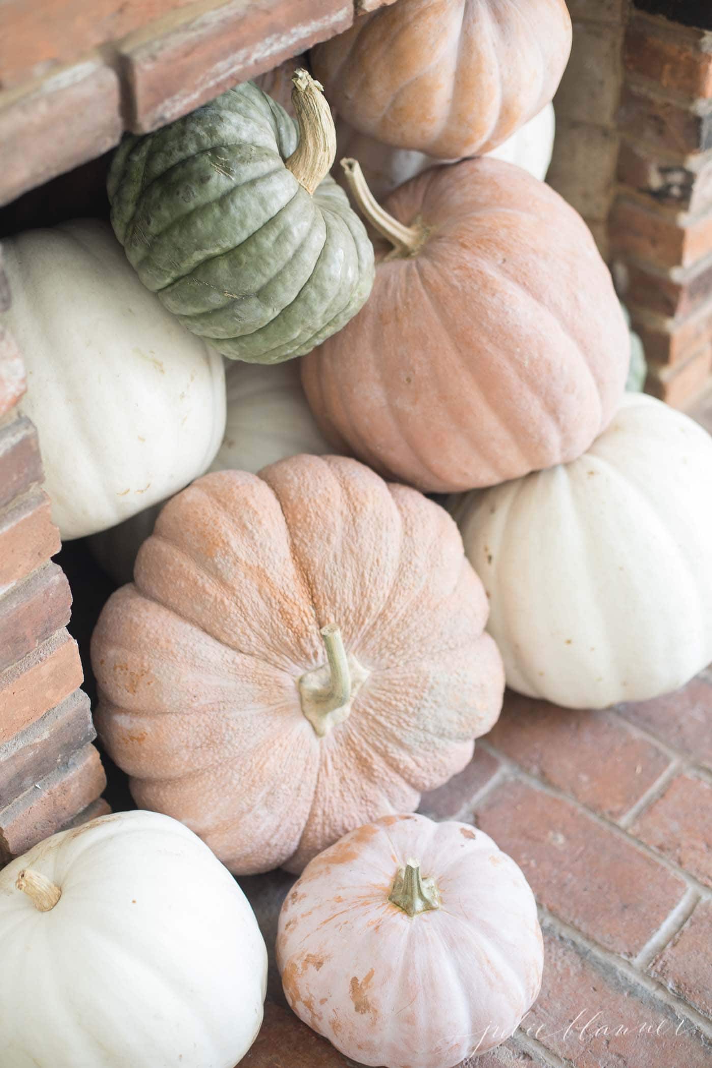 heirloom pumpkins in a fireplace for a fall living room decor idea