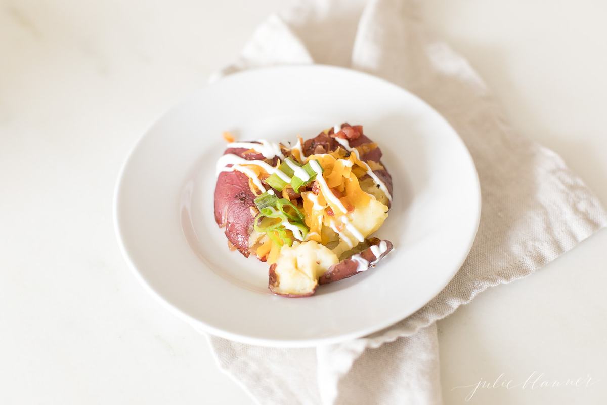 smashed red potatoes topped with cheese bacon sour cream and chives