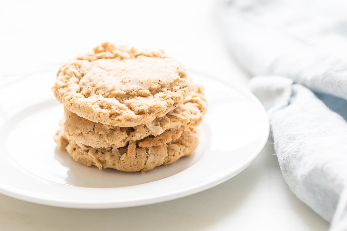 A stack of coconut oatmeal cookies on a white plate. 
