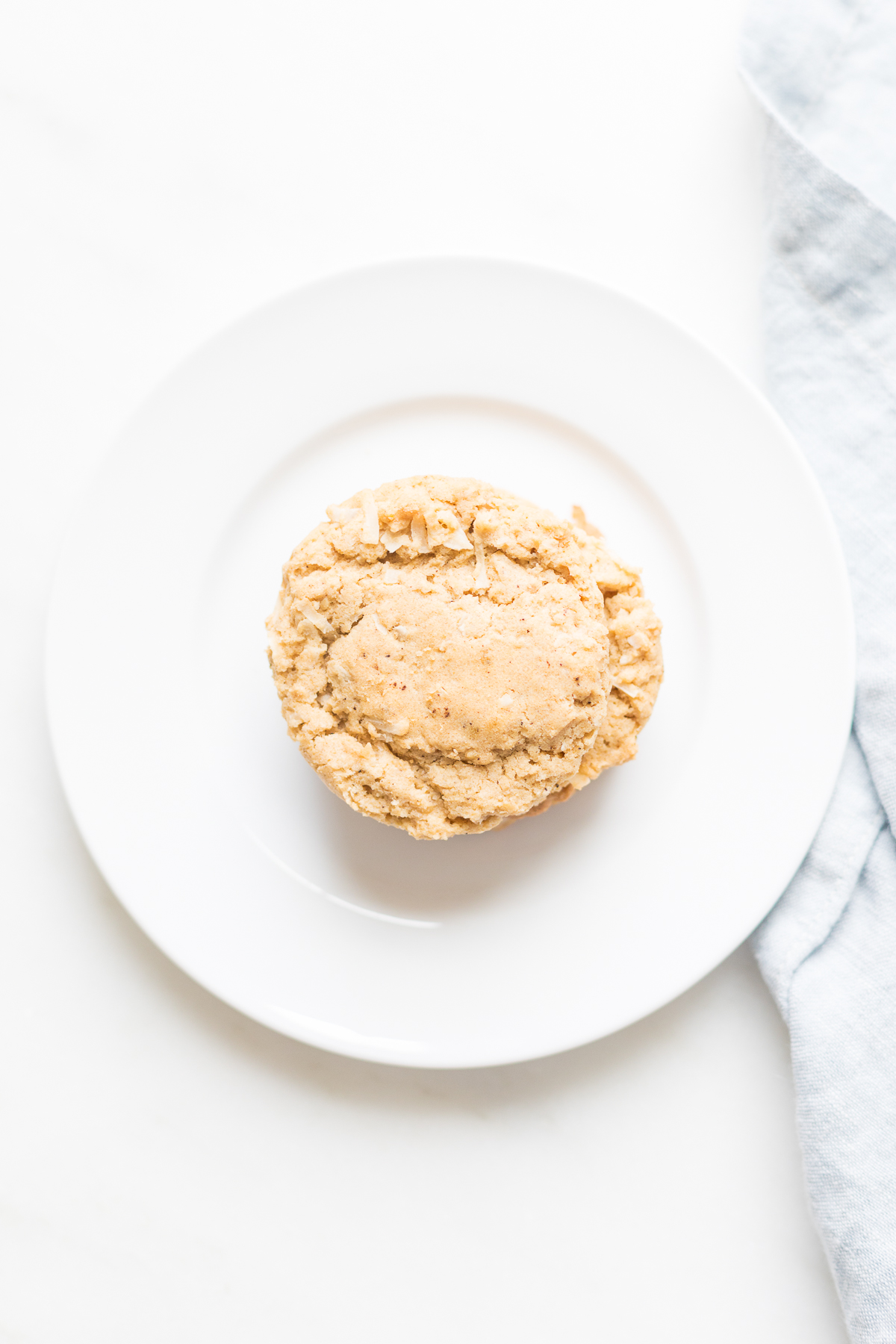 An oatmeal coconut cookie on a white plate.