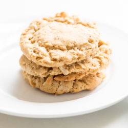 A stack of coconut oatmeal cookies on a white plate.