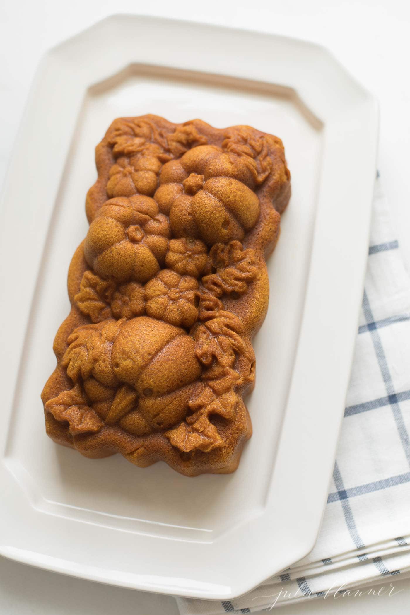 pumpkin pound cake on cream platter with blue checked napkin