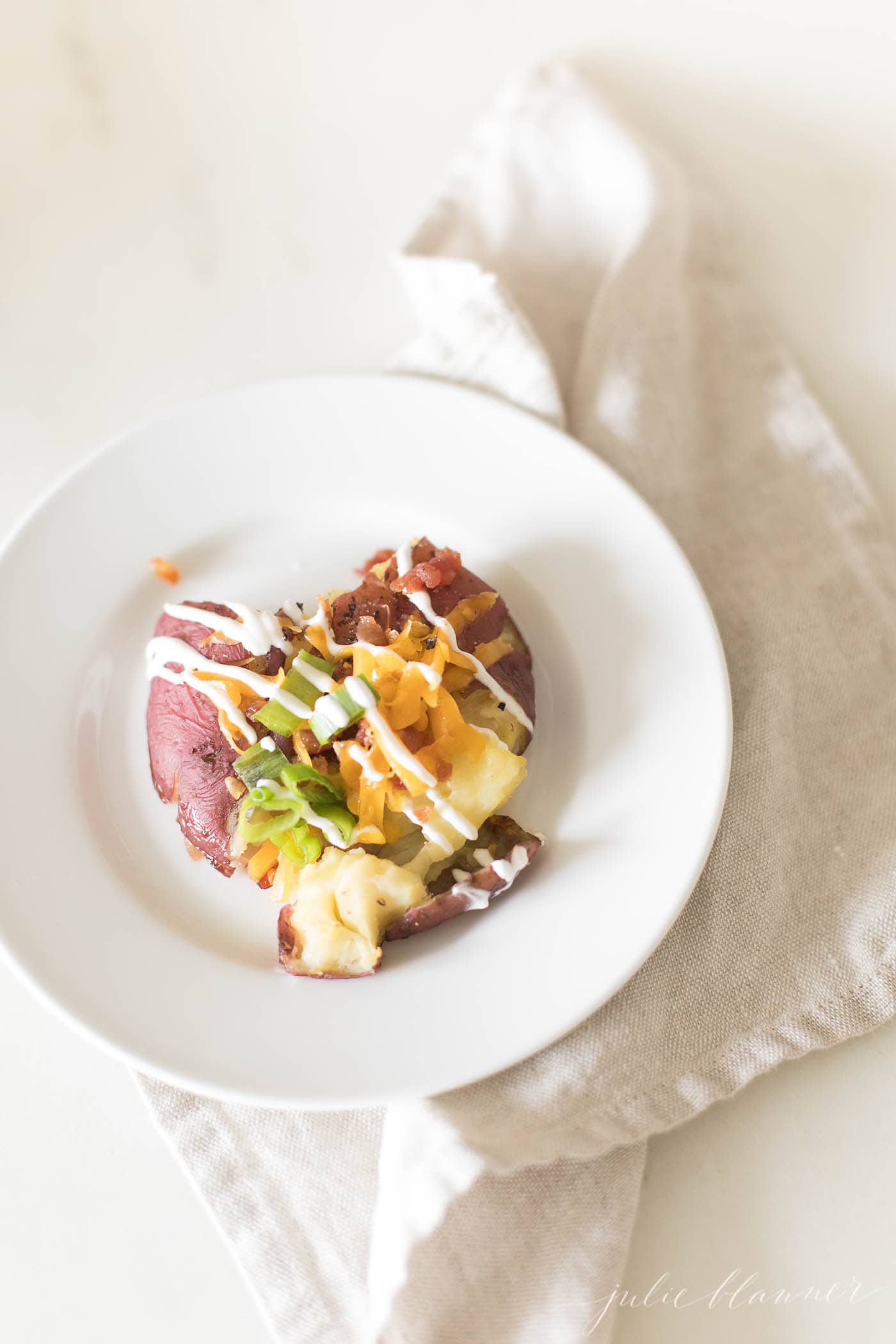 close up on loaded potato on plate with napkin