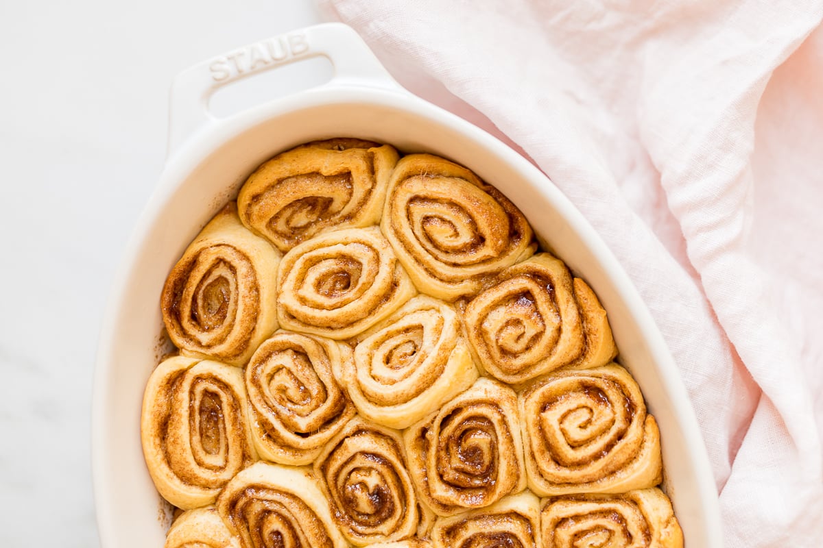 Cinnamon rolls made with crescent rolls in a white oval dish.