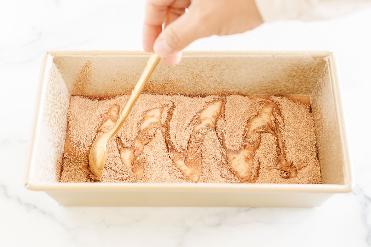 A cinnamon roll loaf in a gold loaf pan, before baking