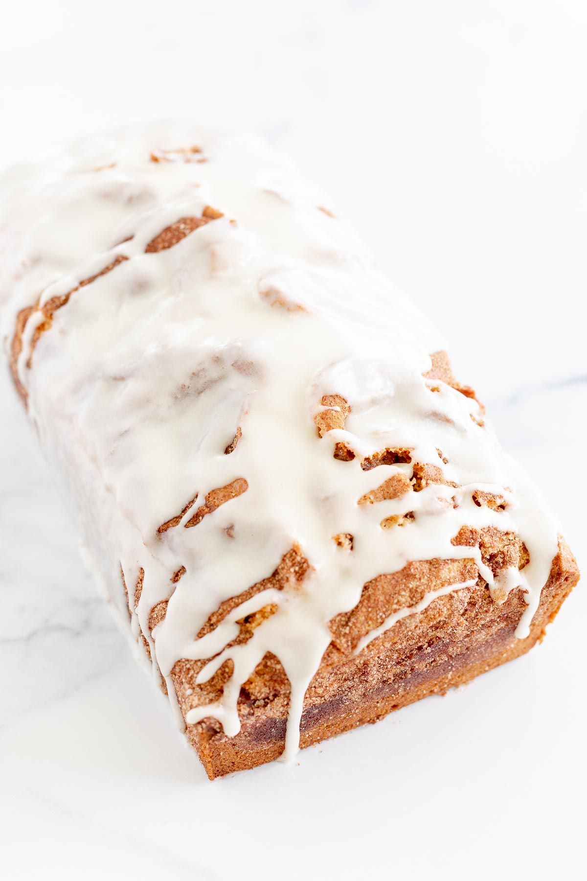 A loaf of cinnamon roll bread drizzled with icing