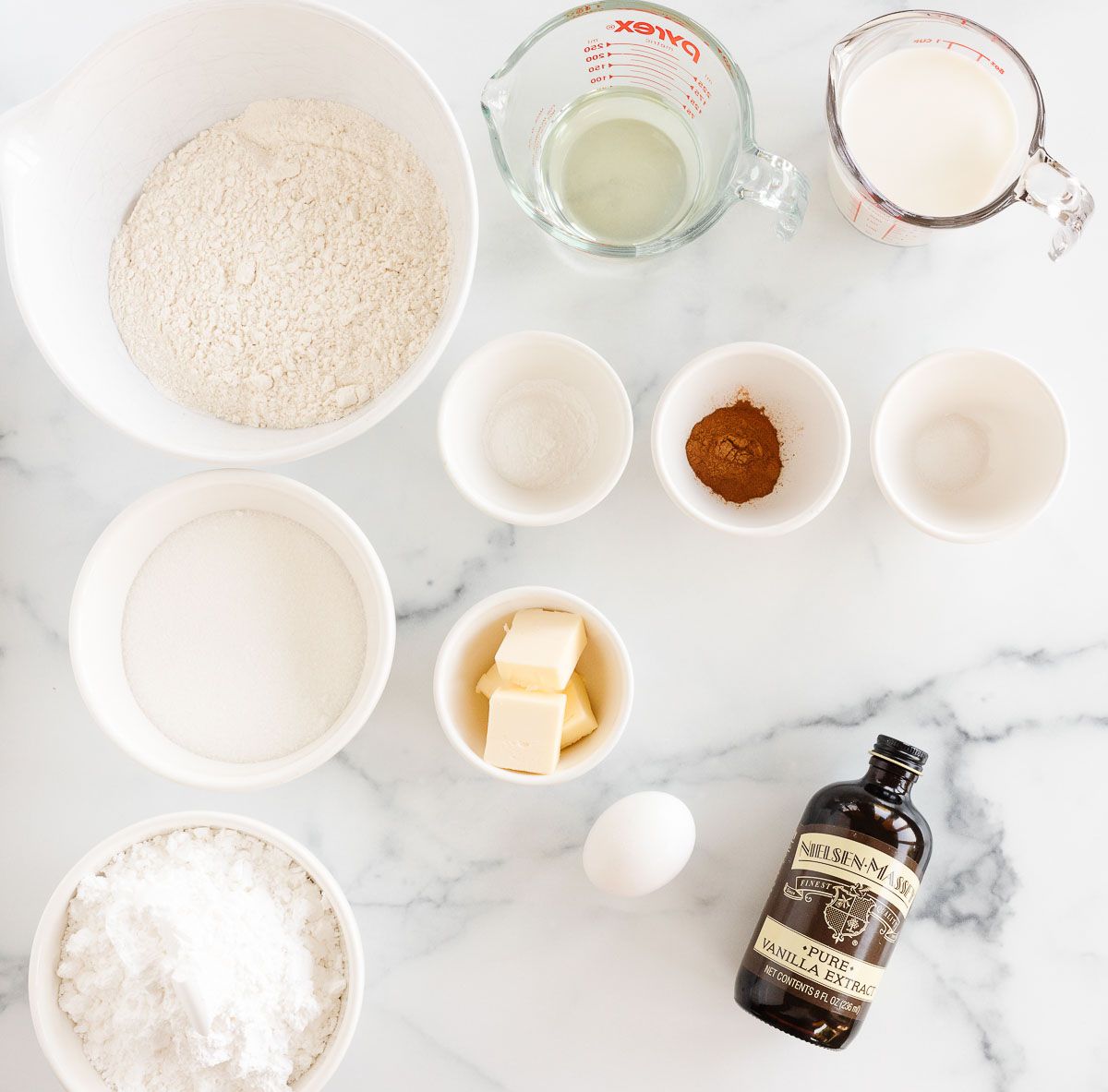Ingredients for a cinnamon roll bread recipe laid out on a marble countertop