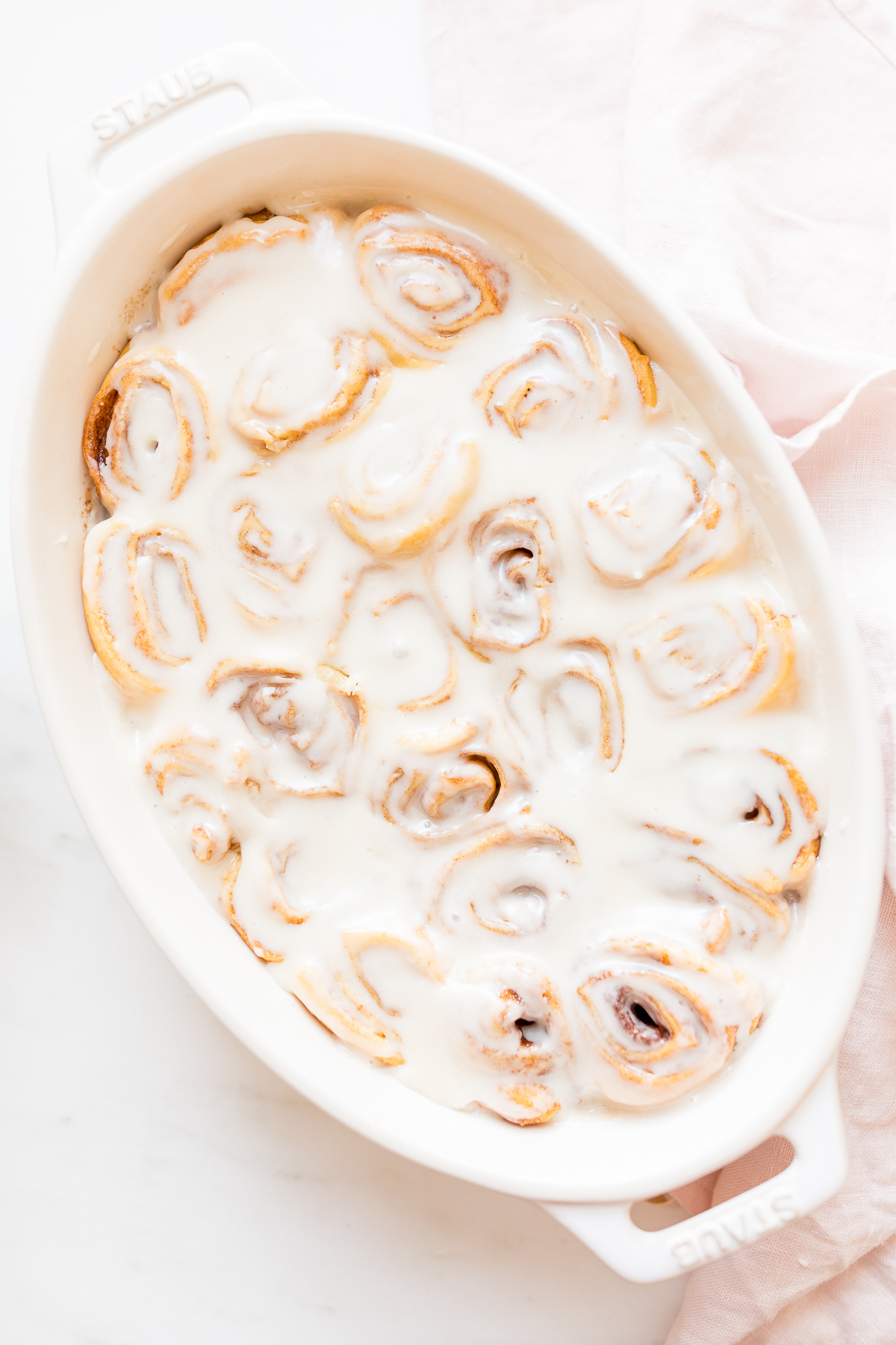 Cinnamon rolls made with crescent rolls in a white oval dish.