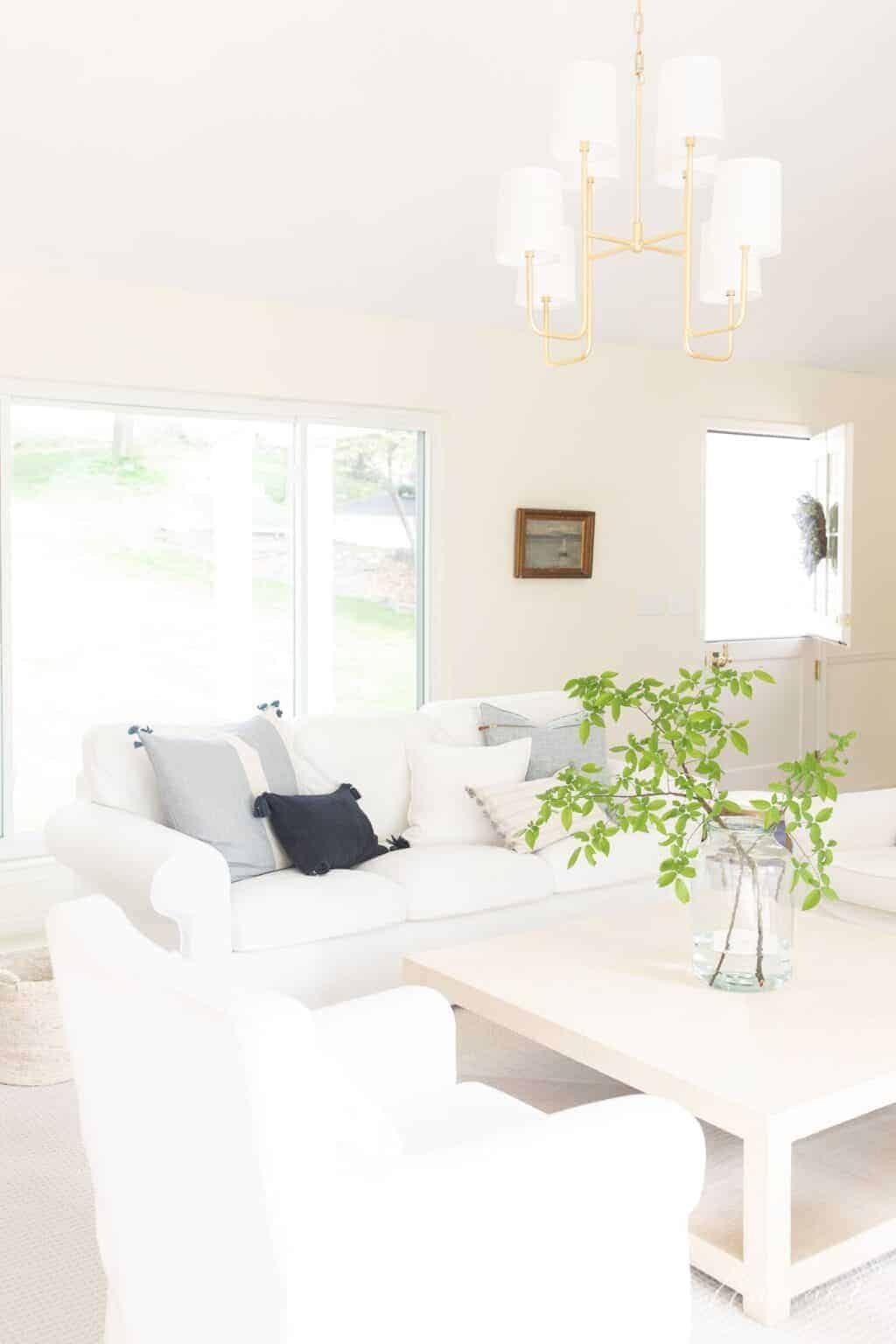A fresh cream and white home with white walls and white sofas and chairs.