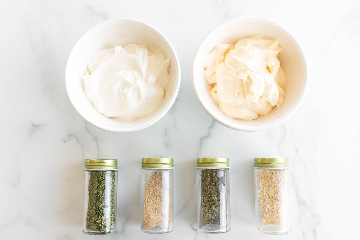 Ingredients for a dill dip recipe on a marble surface