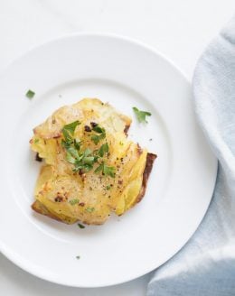 garlic smashed potatoes garnished with herbs