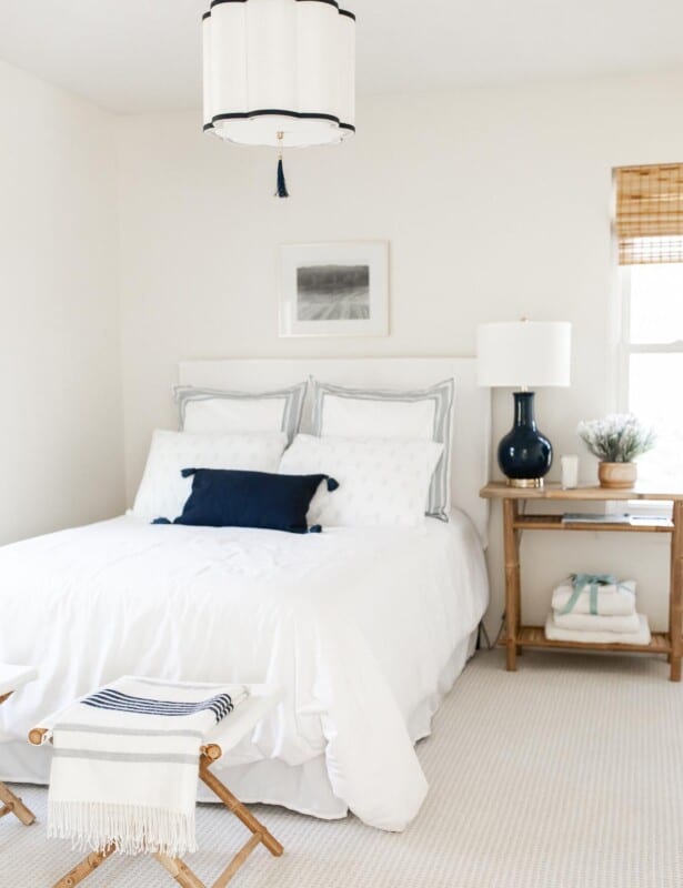 A guest bedroom with a stack of towels on the bedside table.
