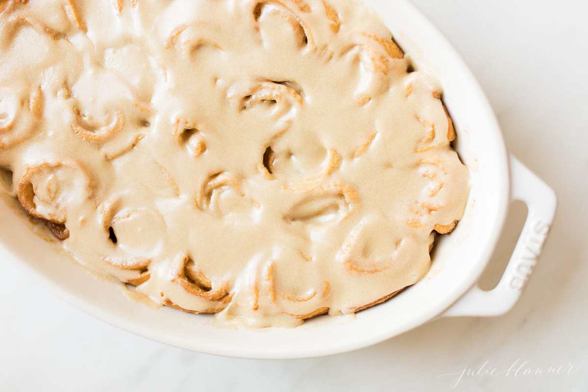 Caramel rolls with frosting in a white dish