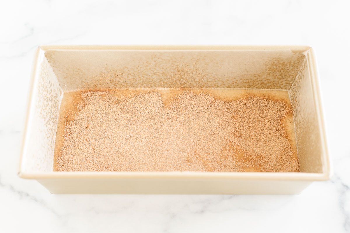 A cinnamon roll loaf in a gold loaf pan, before baking