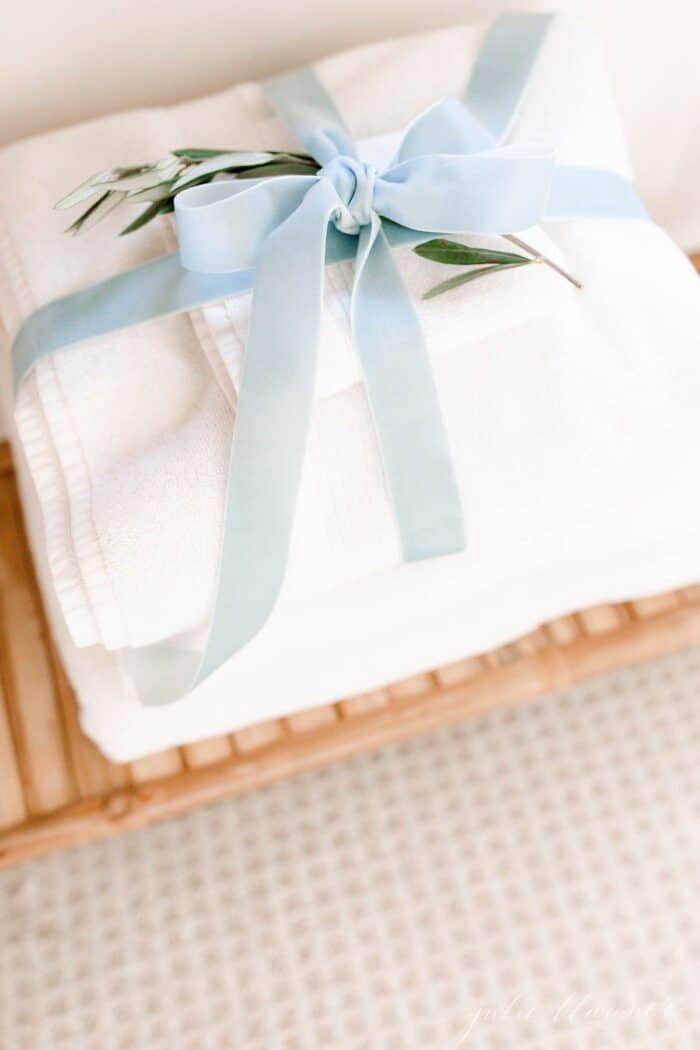 A stack of towels wrapped with velvet ribbon as a guest room idea at Christmas time.