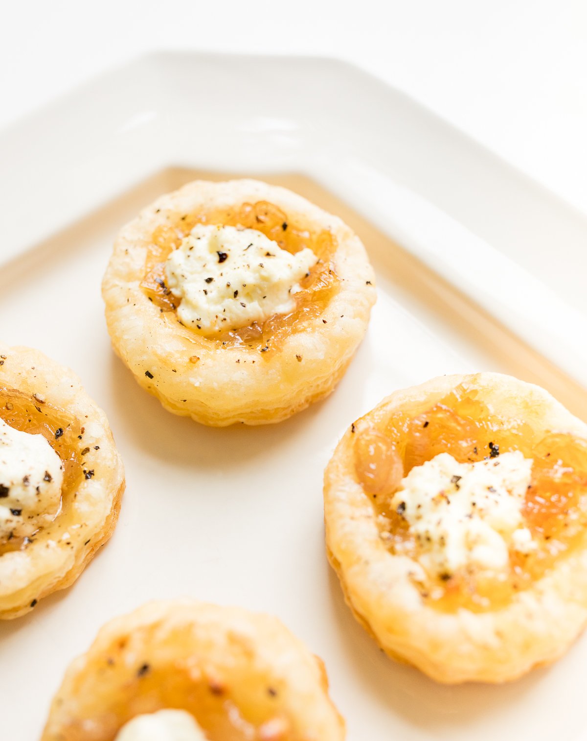 Small miniature onion tarts on a parchment lined pan.