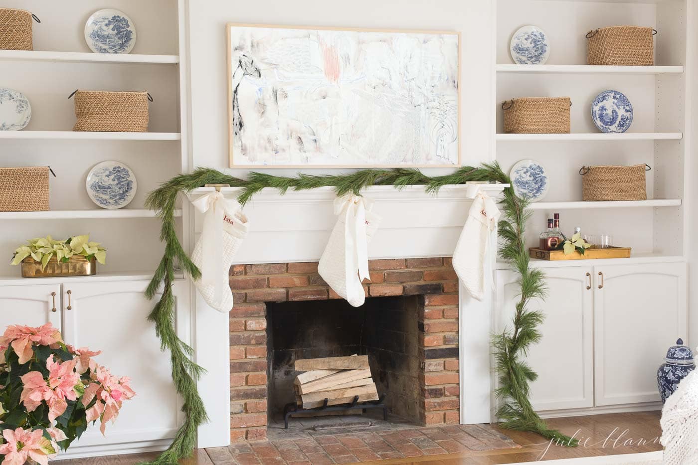 fresh pine garland on a fireplace mantel in a white living room.