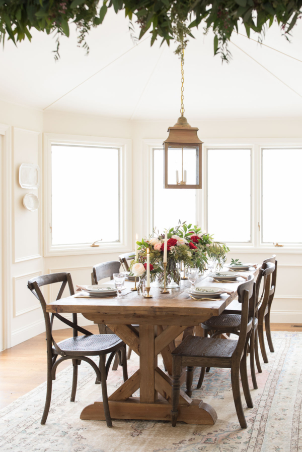 A Christmas-themed dining room with a wooden table and chairs.