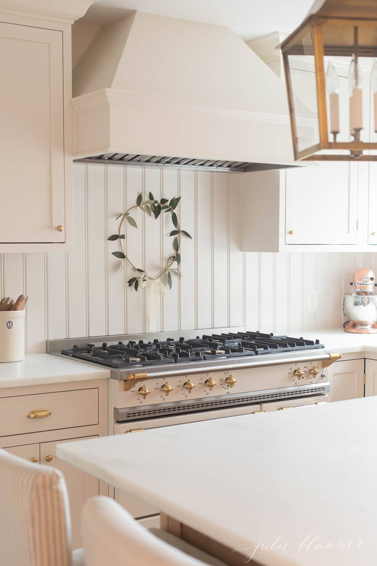 diy christmas wreath behind a range in a white kitchen