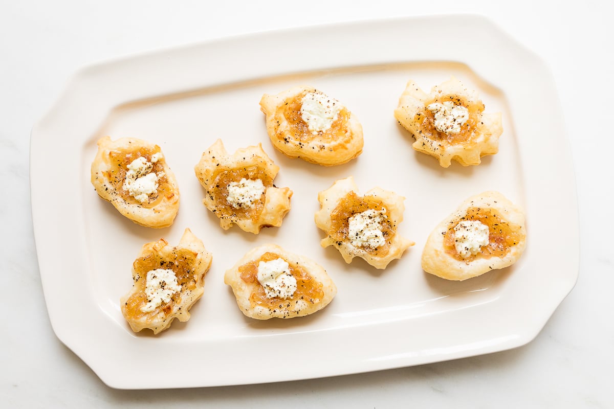 Caramelized shallot tarts on a white platter.