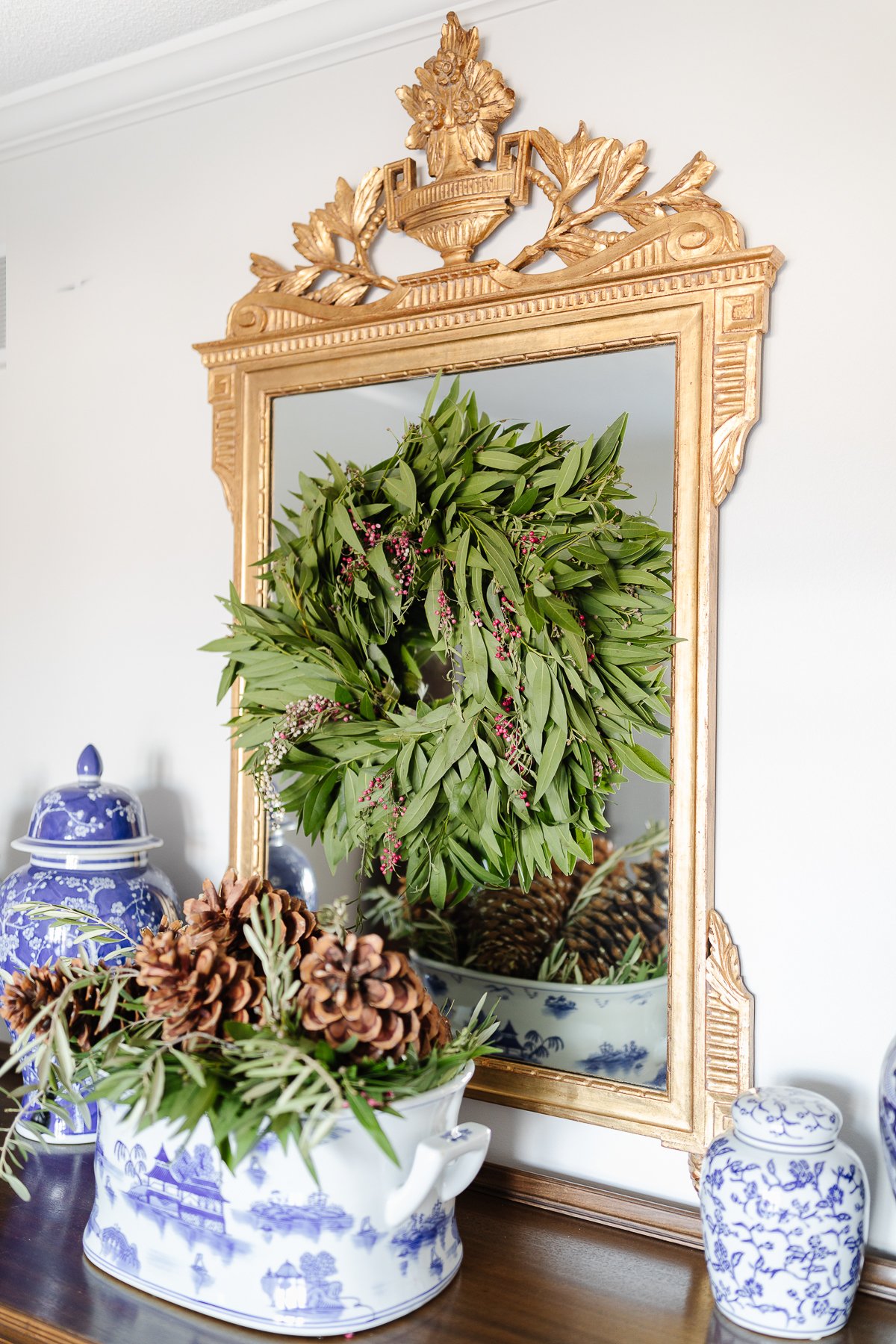 A Christmas wreath adorns a mirror in a house.