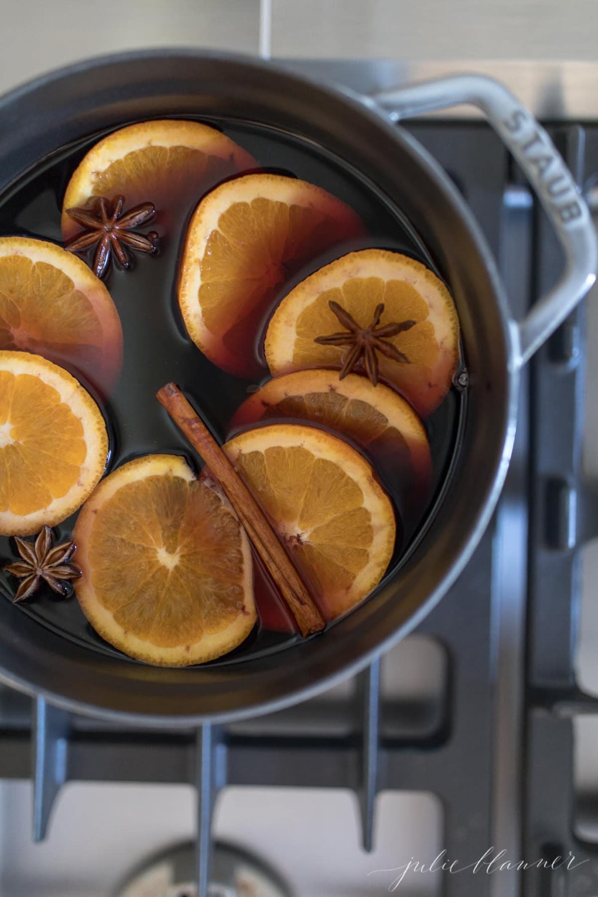 non alcoholic mulled grape juice on the stovetop with orange slices and spices