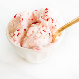 Candy cane ice cream in a bowl with a gold spoon.