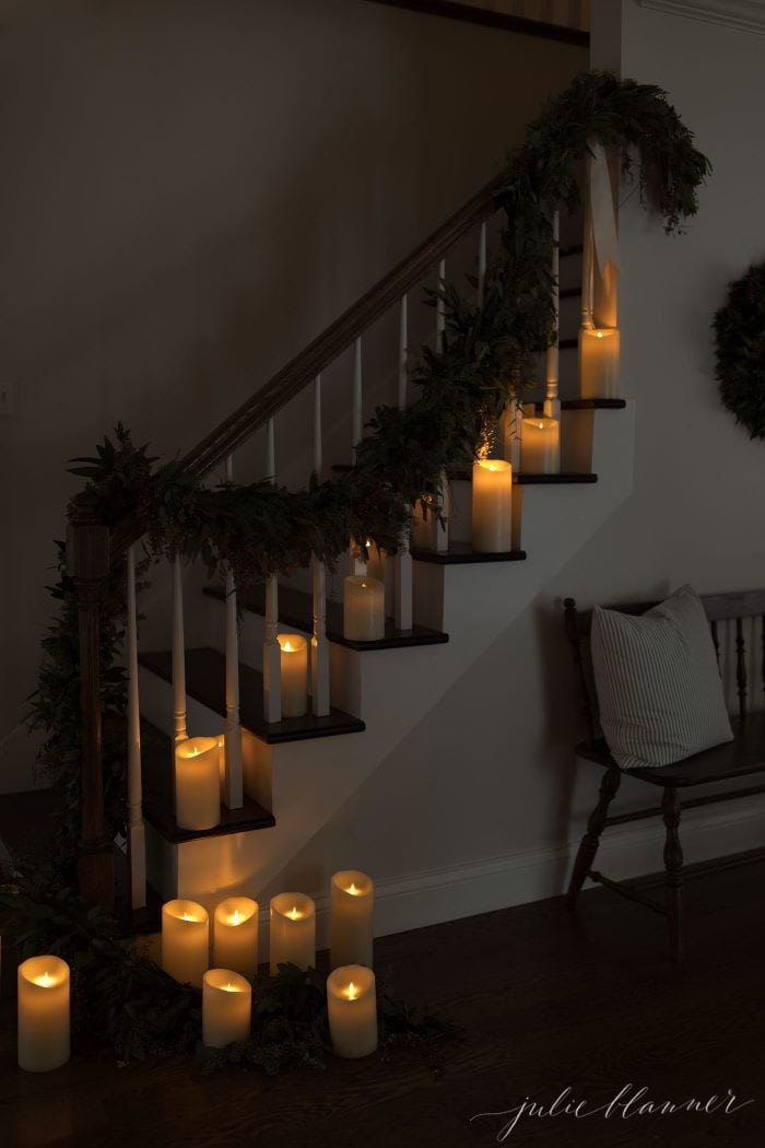 Stairs lined with candles and festive greenery. 