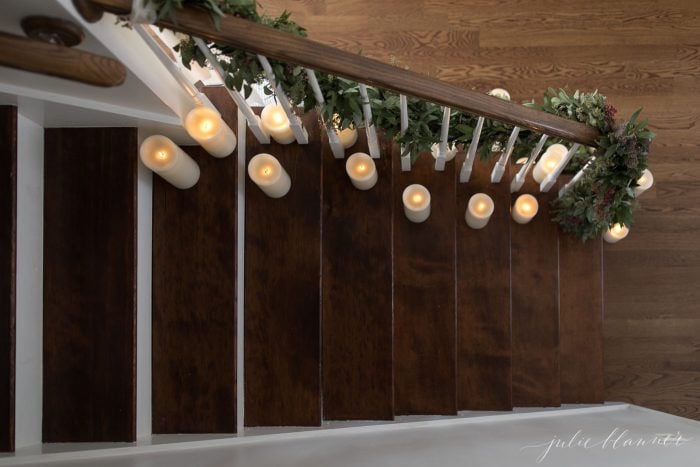 Stairs lines with candles and festive greenery. 