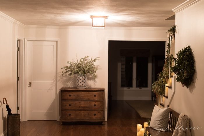 Stairs lined with candles and festive greenery. 