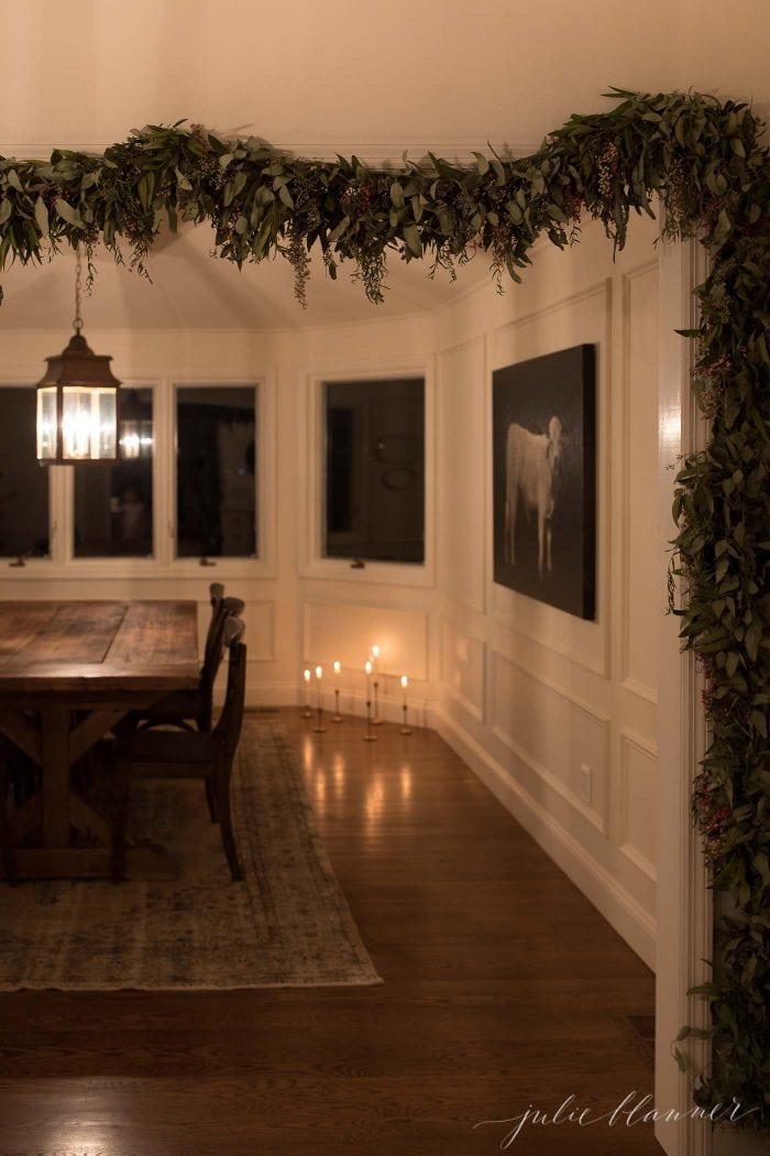 a breakfast room with a brass pendant lined with garland for christmas 