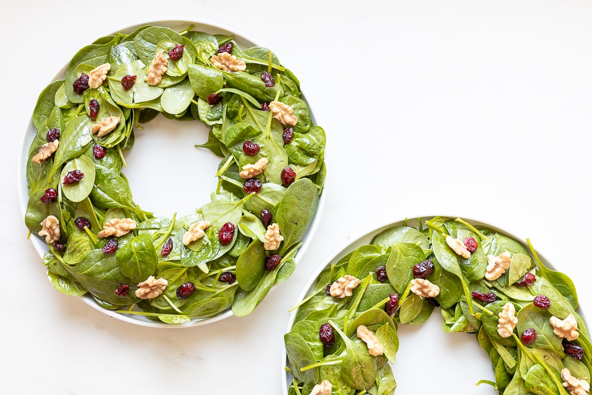 Easy Christmas salad with cranberries and walnuts on two plates.