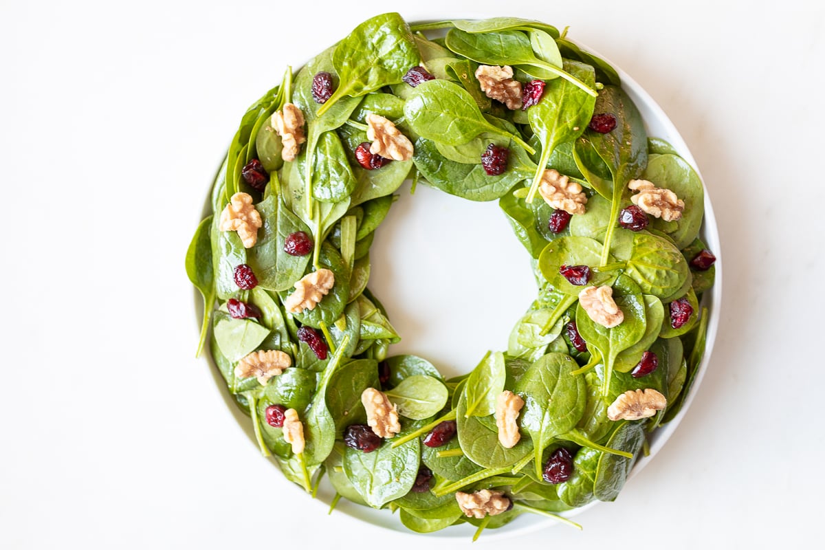 Easy Christmas salad featuring spinach, walnuts, and cranberries.