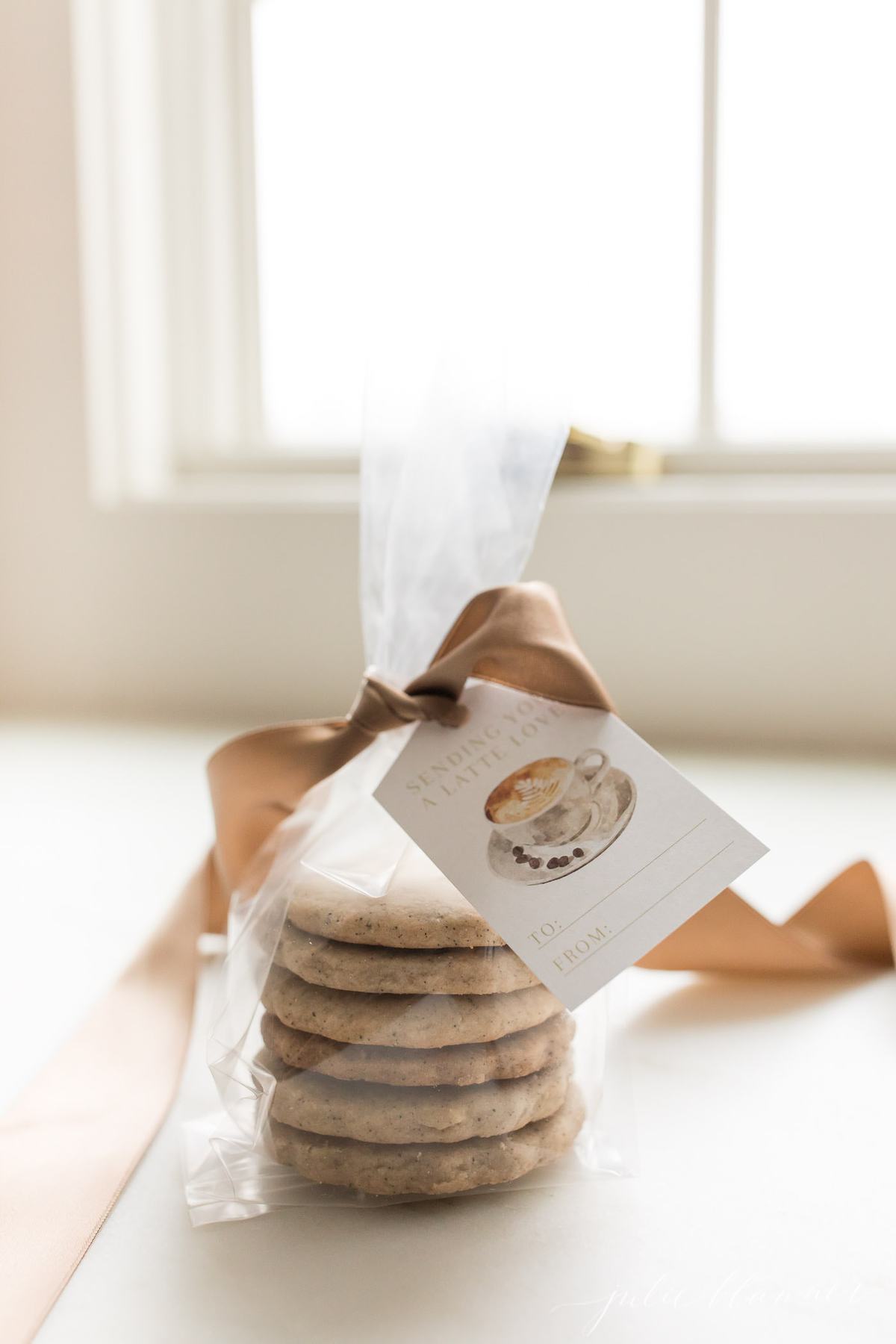 espresso cookies in a cello wrapped stack, tied with a brown satin bow and gift tag that reads "sending you a latte love"