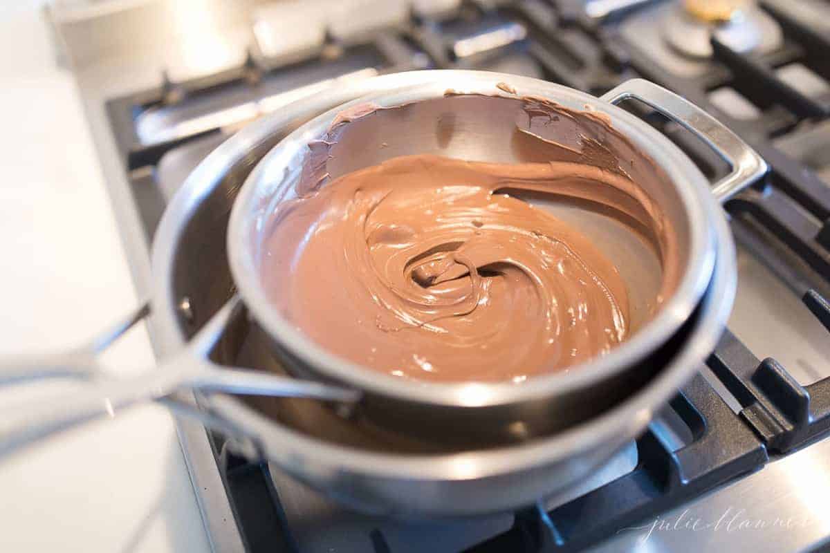 A double broiler set up full of melted chocolate for peppermint chocolate bark.