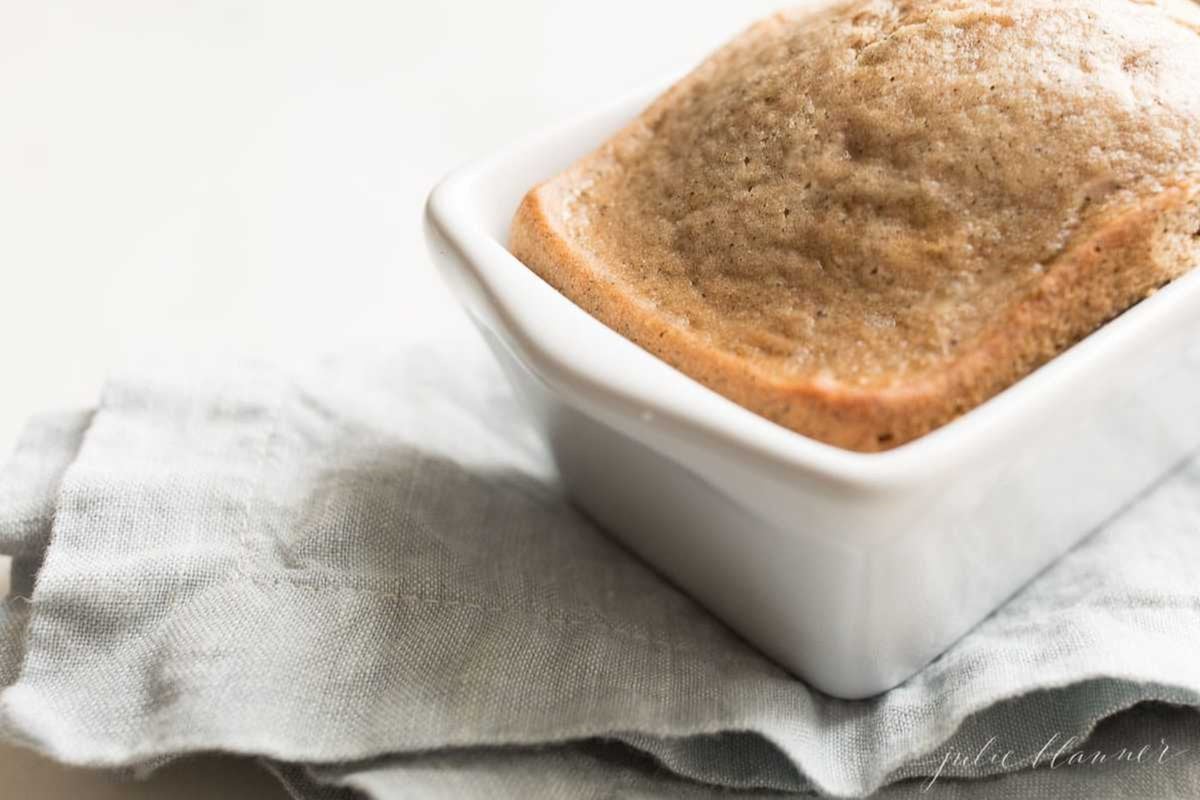 An espresso bread in a small white loaf pan, on a blue kitchen towel.