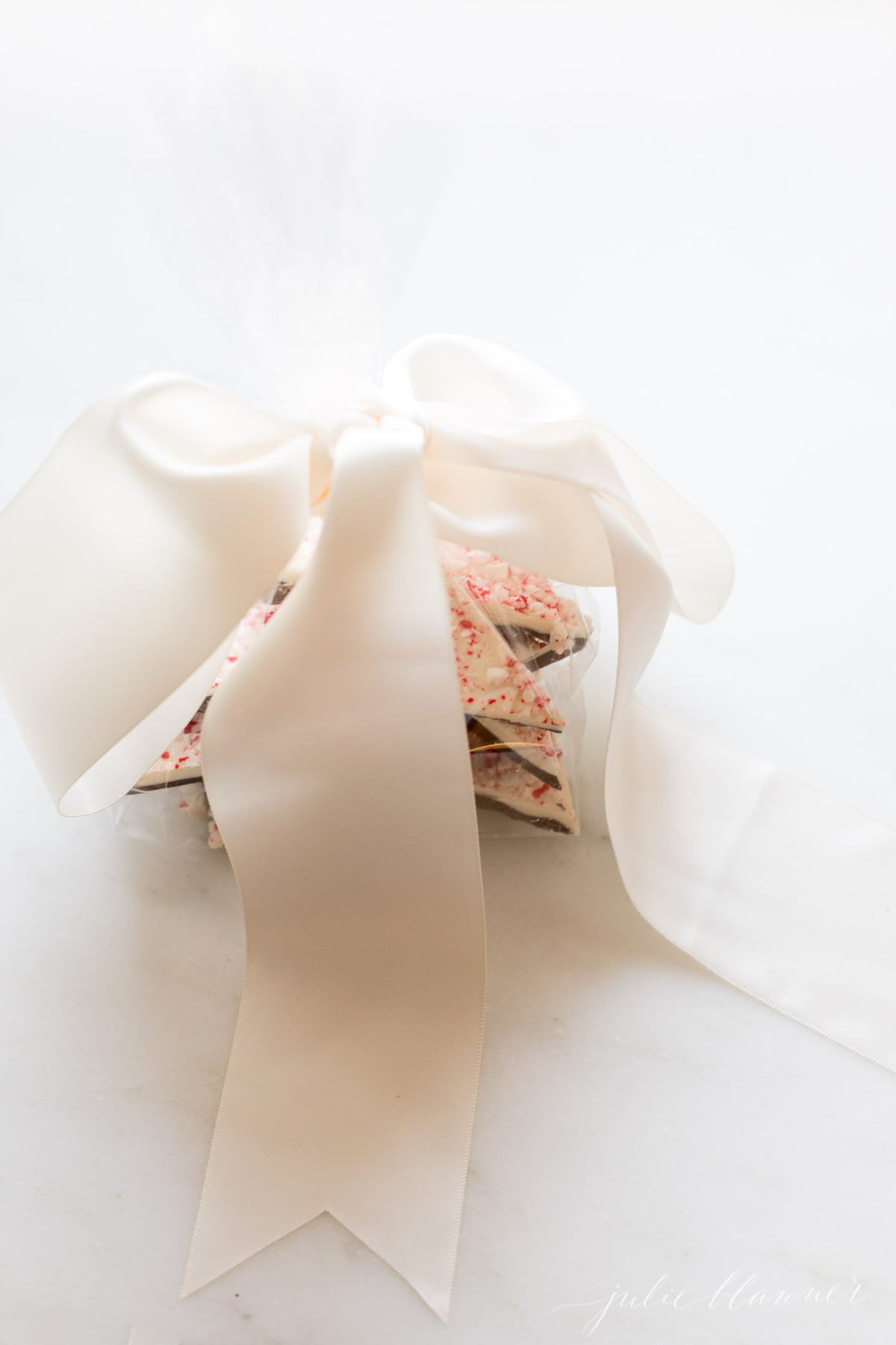 Salted Peppermint Bark | a new twist on the classic Christmas candy! #christmas #candy #gift #easyrecipe salted peppermint bark gift wrapped with a large bow