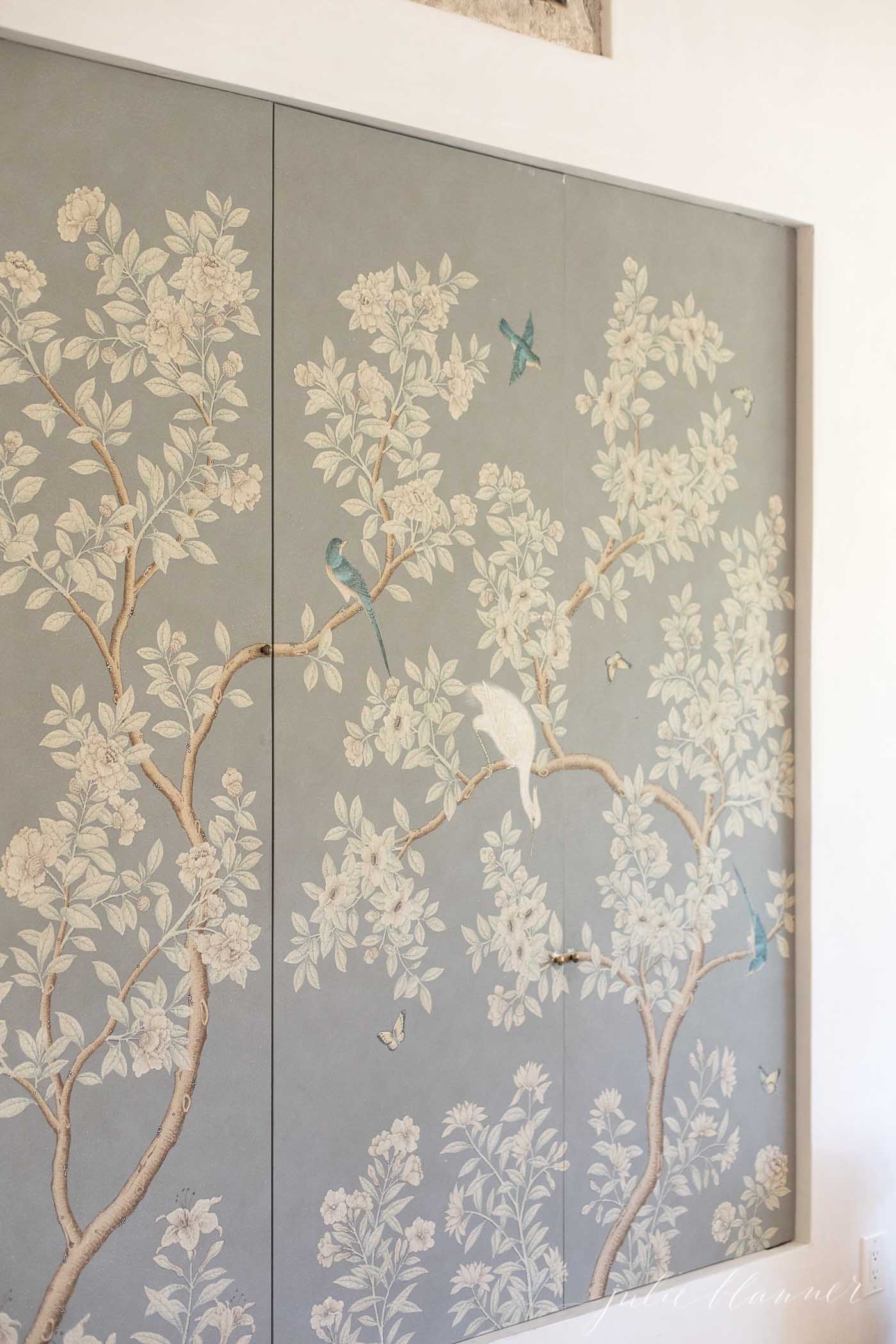 A floral screen in faded pastel colors, with birds on the branches