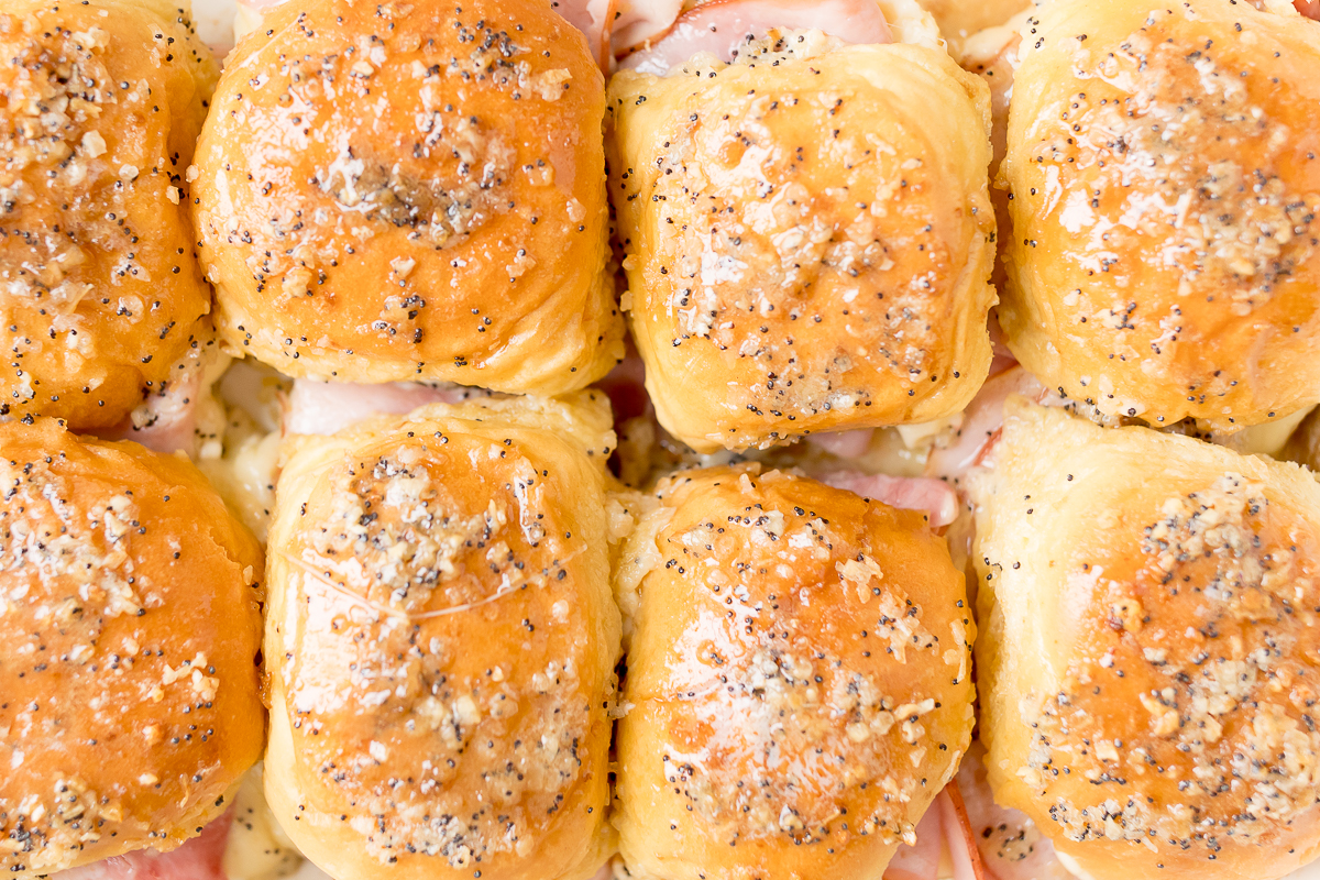 Hot ham and cheese sliders on a baking sheet.