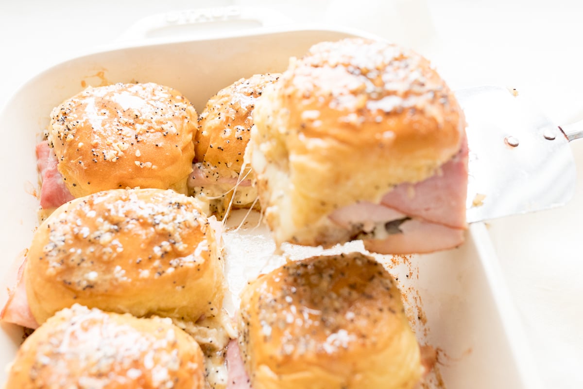 Hot ham and cheese sliders in a baking dish.