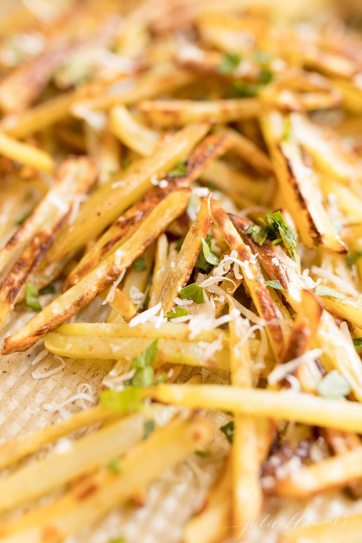fries with Parmesan and parsley on a sheet pan