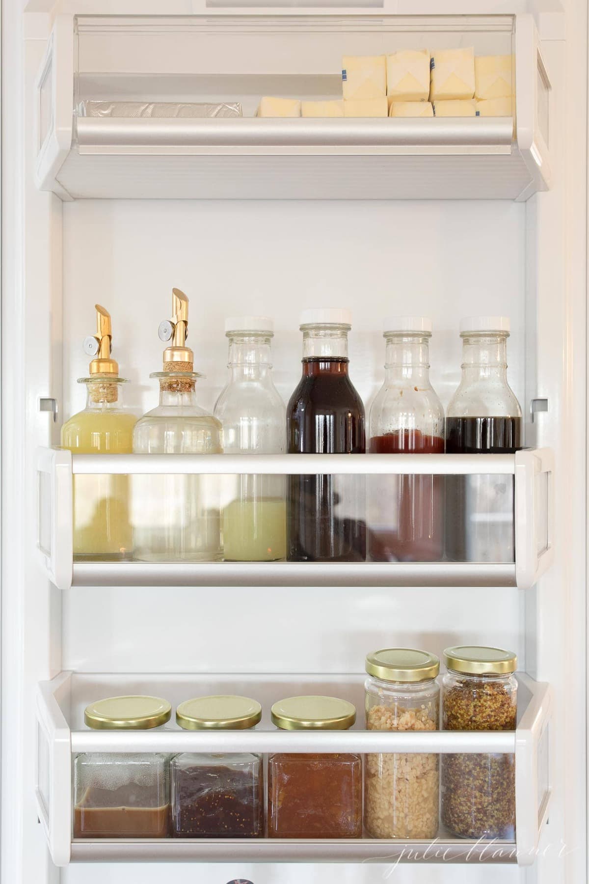 refrigerator organization with clear jars inside a fridge door.