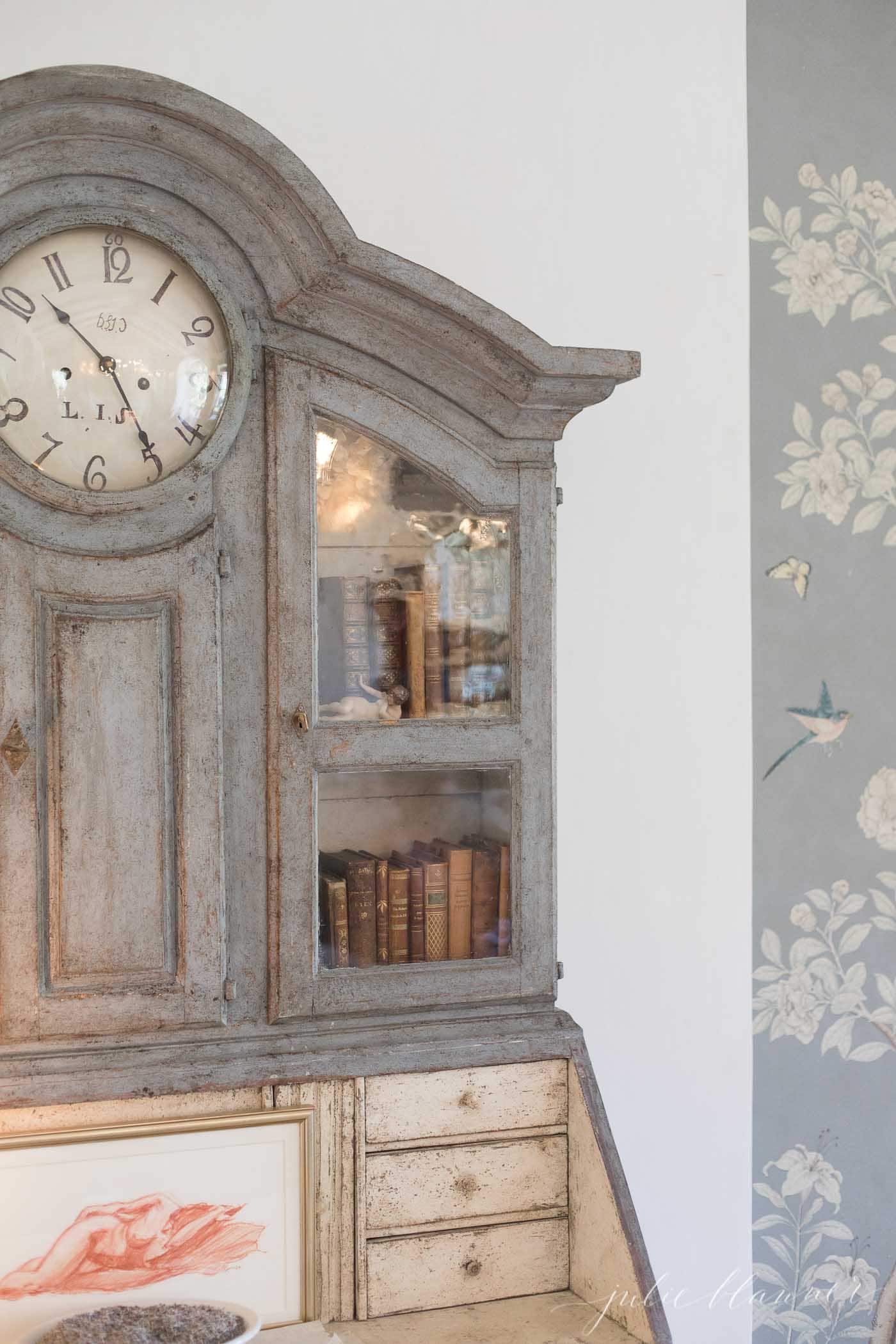 An old painted grandfather clock with a gray finish.