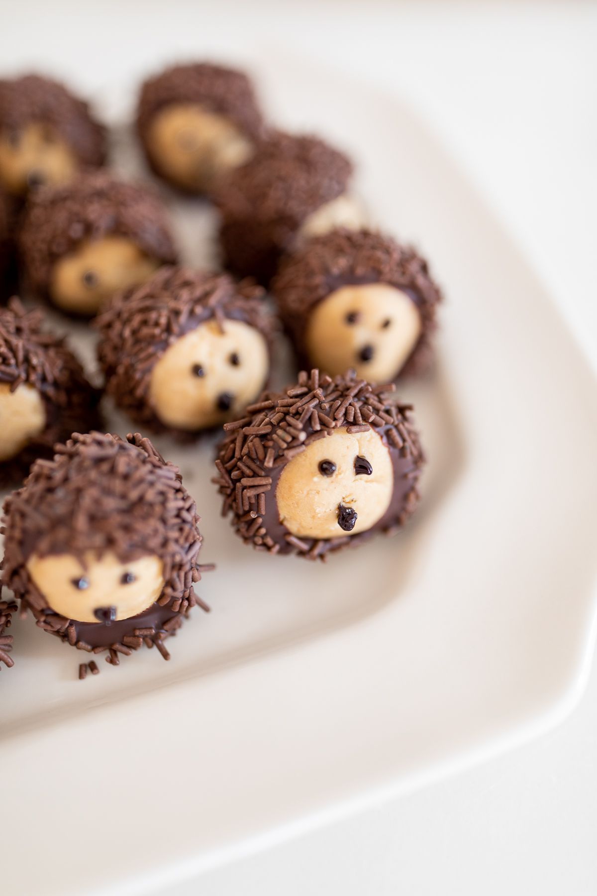 Buckeye balls shaped into hedgehogs on a white platter.