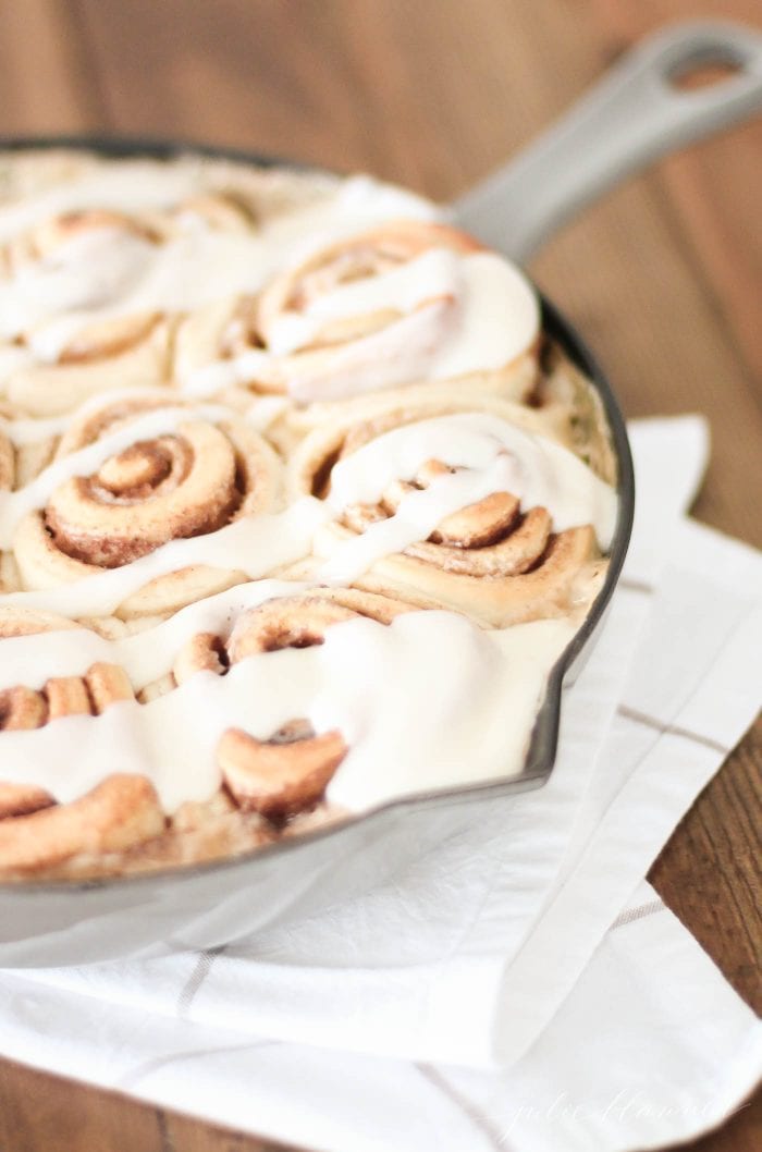 cream cheese icing drizzled on cinnamon rolls