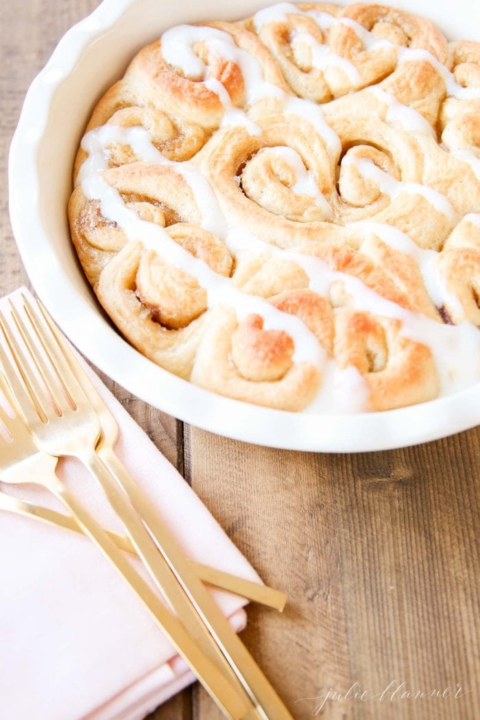 cream cheese icing drizzled on cinnamon rolls