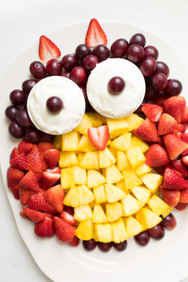 A fruit tray shaped into an owl, featuring cream cheese fruit dip as the owl's eyes.