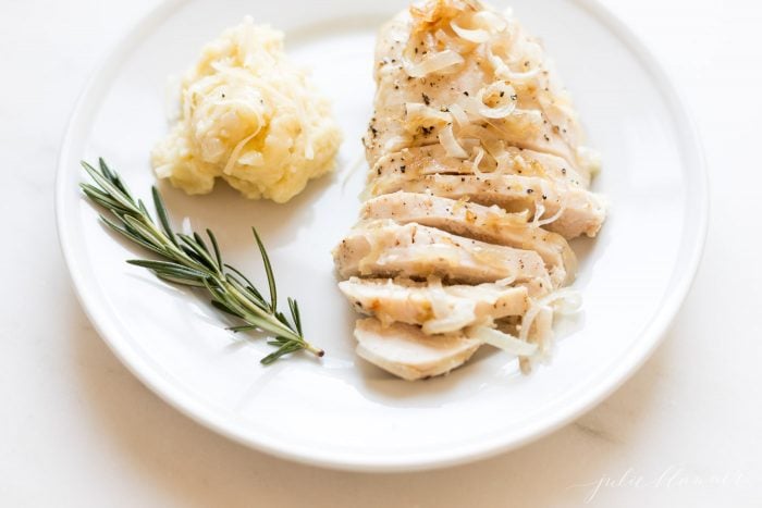 garlic chicken with caramelized shallots on a plate with mashed potatoes